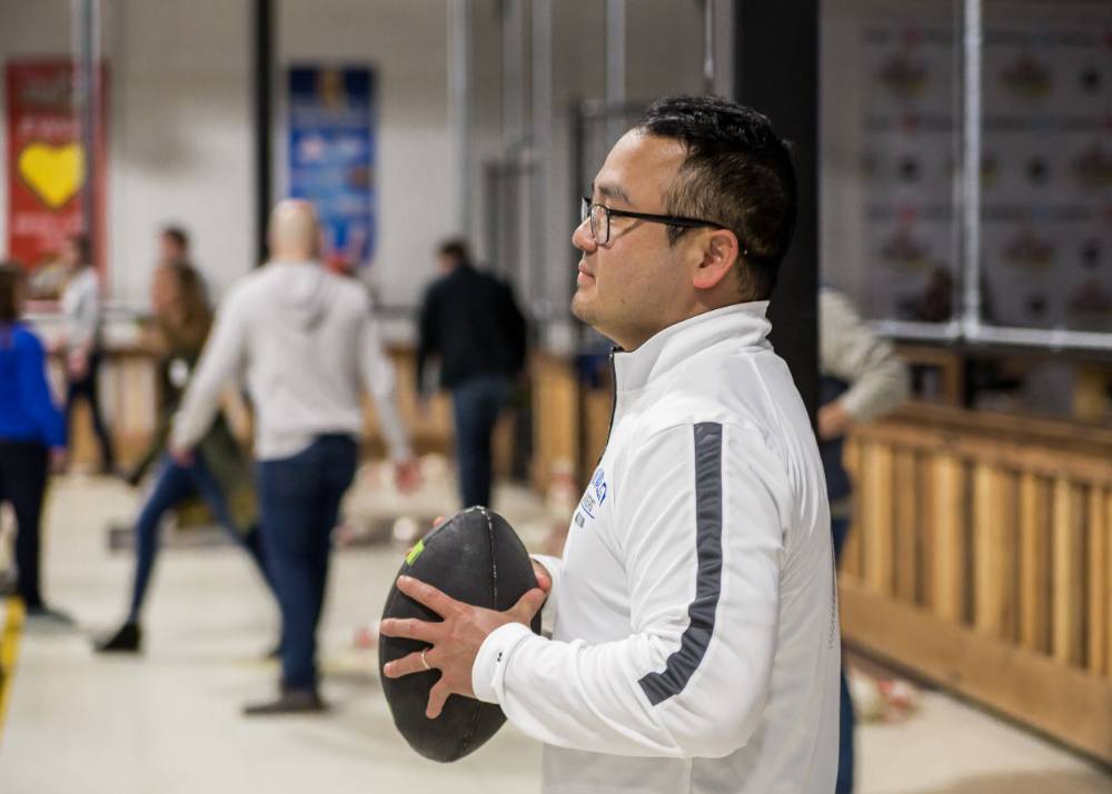An alumnus holding the football at the Fowling Fun Event